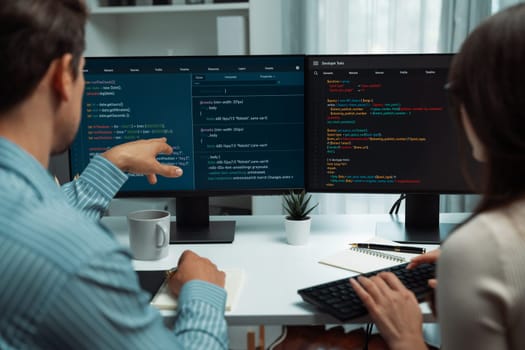 Team skilled developers program coding discussing creative website planning software project on two screen monitor's full stack data analyzing design at office with back side view concept. Postulate.