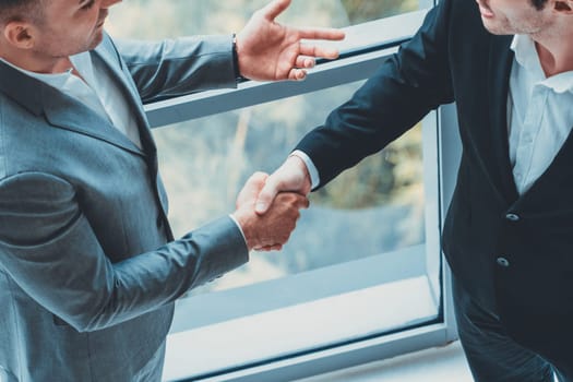 Businessman handshake with another businessman partner in modern workplace office. People corporate business deals concept. uds