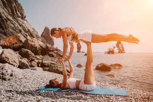 Woman sea yoga. Back view of free calm happy satisfied woman with long hair standing on top rock with yoga position against of sky by the sea. Healthy lifestyle outdoors in nature, fitness concept.