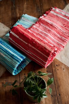 Two handmade Cotton rag rugs, traditional carpet on wooden background with plant