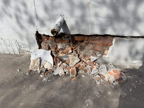 collapsed plaster on a red brick wall