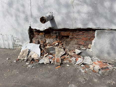 collapsed plaster on a red brick wall