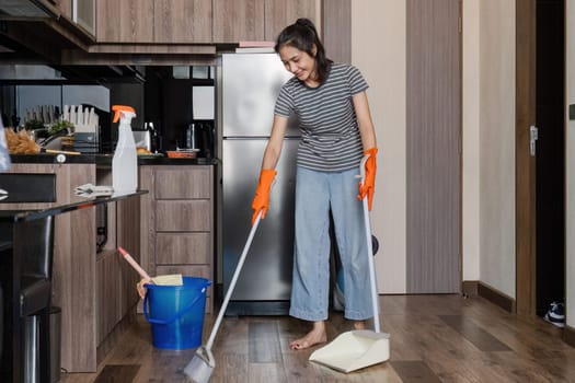 Asian woman cleaning house during weekend, sweeping floor house. cleaning day concept.