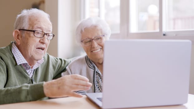 Senior people talking during an online meeting using laptop in geriatric