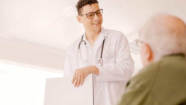 Doctor smiling kindly at an older man in a hospital