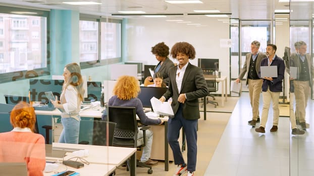 Group of diverse coworkers arriving at the office and sitting on desk