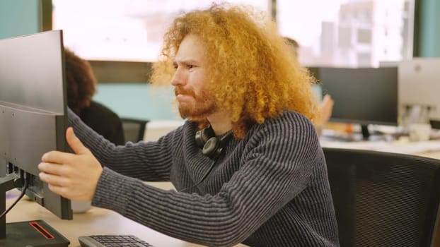 An angry worker experiencing computer problems in a coworking