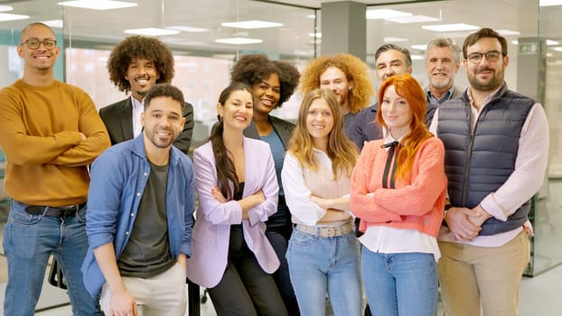 Multi-ethnic and multi-generational group of colleagues smiling at camera in a coworking space
