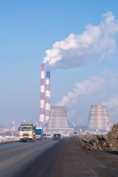 Naberezhnye Chelny, Russia, March 2, 2024. The factory is emitting smoke into the sky, polluting the air with gas. The building is located on an asphalt road surface, surrounded by vehicles