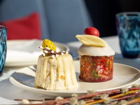 Traditional Easter cottage cheese dessert Paskha decorated with quail eggs and chocolate willow on tabletop background. Modern Orthodox Easter background with two mini cottage curd desserts Paskha