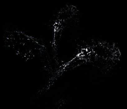 Long stream of fresh transparent water isolated on black background. Splash and drops