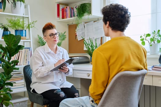 Female professional psychologist mental therapist working with young guy in office. Social worker counselor psychotherapist helping patient with difficulties stress depression. Psychology psychotherapy