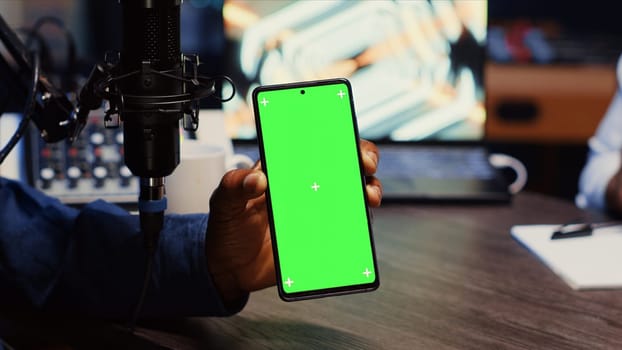 Isolated screen smartphone hold by presenter on podcast discussing with guest during marathon stream for humanitarian cause. Mockup mobile phone used by host to check gathered donations from audience