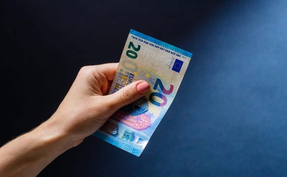 Hand holding twenty euro banknote after money exchange. European currency in cash as symbol of success