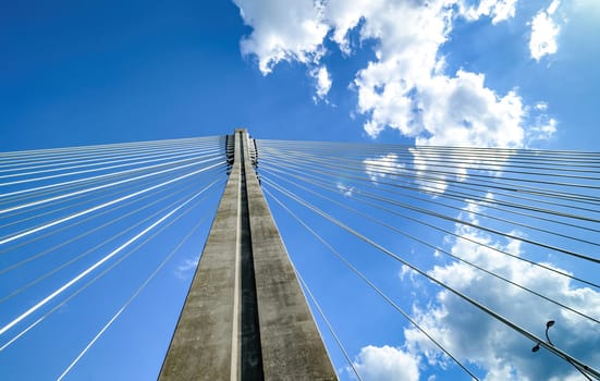 big metal Bridge support with ropes against the bright blue sky