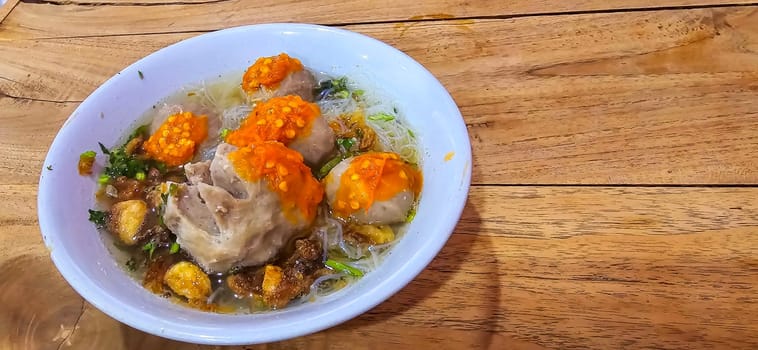 Bakso, indonesian meatball style served with beef broth soup and noodle springkled with fried onion and spring onion coupled with chili sauce on the top, very famous Asian street food