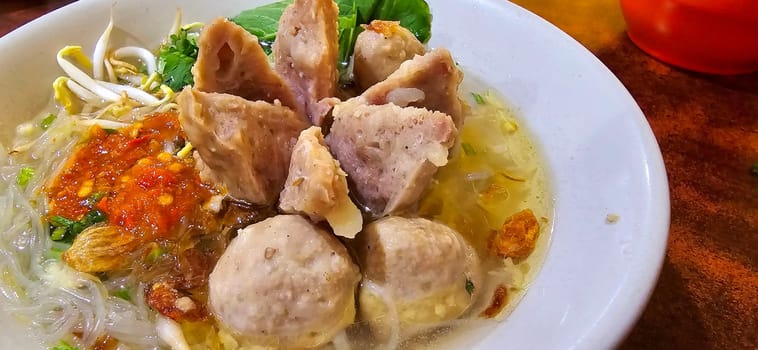 Bakso, indonesian meatball style served with beef broth soup and noodle springkled with fried onion and spring onion coupled with chili sauce on the top, very famous Asian street food