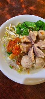 Bakso, indonesian meatball style served with beef broth soup and noodle springkled with fried onion and spring onion coupled with chili sauce on the top, very famous Asian street food