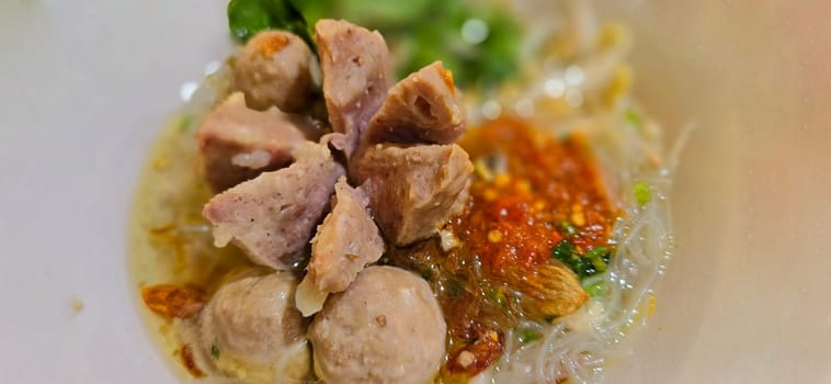 Bakso, indonesian meatball style served with beef broth soup and noodle springkled with fried onion and spring onion coupled with chili sauce on the top, very famous Asian street food