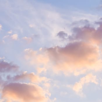 Background of blue sky with pale pink clouds at sunset