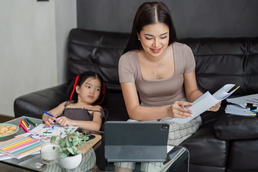 business woman work from home and take care of her child while working, doing activities with her child while working.