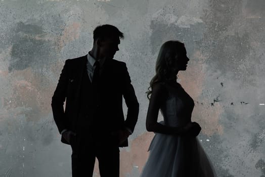 Art fashion studio photo of wedding couple silhouette groom and bride on colors background. Art Wedding style.