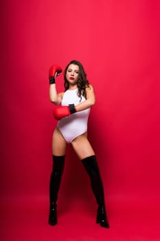 Seductive young female in violet bodysuit on a dark and red background
