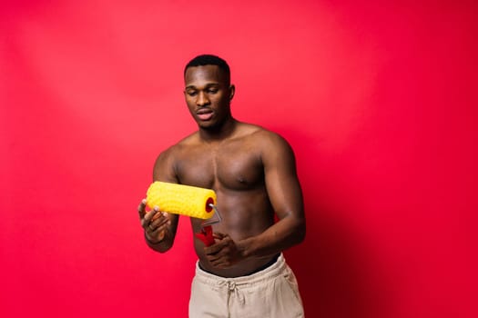 African-American painter on a red studio background topless
