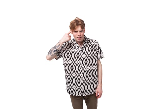 young indignant european man with golden hair is dressed in a stylish black and white shirt on a studio background with copy space.