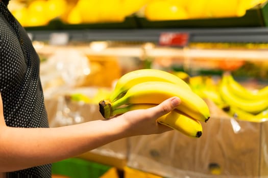 Boy holding a bunch of bananas in a supermarket