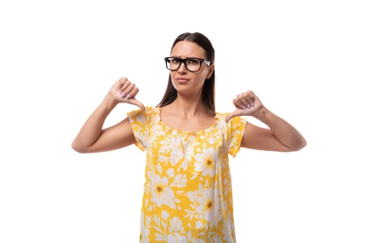 young serious brunette woman with glasses dressed in a summer orange T-shirt points at herself with her hands.