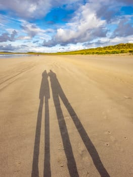 Shadow of couple enjoying the beach.