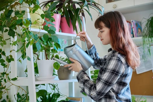 Young woman watering pots with plants from watering can, home interior. Home landscaping, eco green trends, lifestyle concept