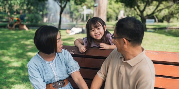 Family day, family picnic together at the park. Retired grandparent take granddaughter to relax and spend time together at the park.