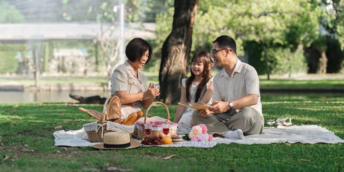 Family day, family picnic together at the park. Retired grandparent take granddaughter to relax and spend time together at the park.