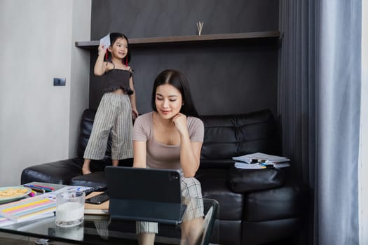 Businessman working at home. working woman talk on mobile and working on tablet and take care of her daughter during summer.