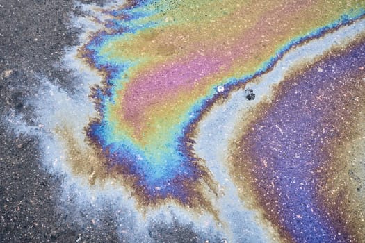 The oil left behind after rain forms spots that refract the sun's spectrum like a rainbow