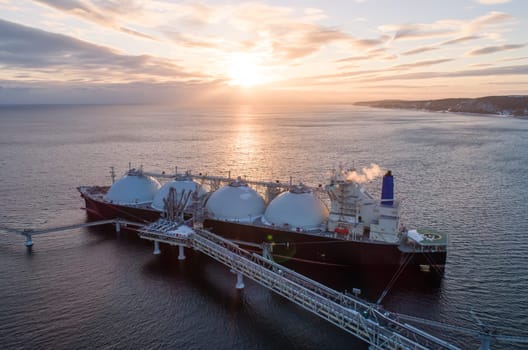 Aerial of Liquified Natural Gas LNG carrier moored to a small gas terminal. Fuel crisis. Sanctions.