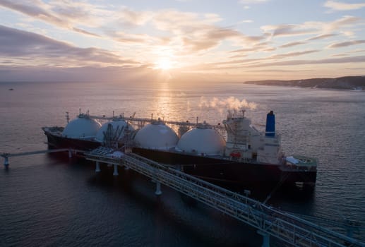 Aerial of Liquified Natural Gas LNG carrier moored to a small gas terminal. Fuel crisis. Sanctions.