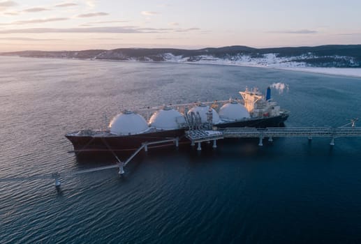 Aerial of Liquified Natural Gas LNG carrier moored to a small gas terminal. Fuel crisis. Sanctions.