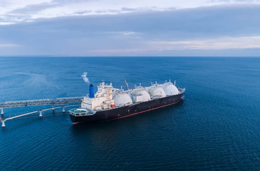 Aerial of Liquified Natural Gas LNG carrier moored to a small gas terminal. Fuel crisis. Sanctions.