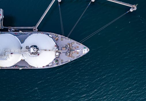 Aerial of Liquified Natural Gas LNG carrier moored to a small gas terminal. Fuel crisis. Sanctions. Top down view of a ship bow