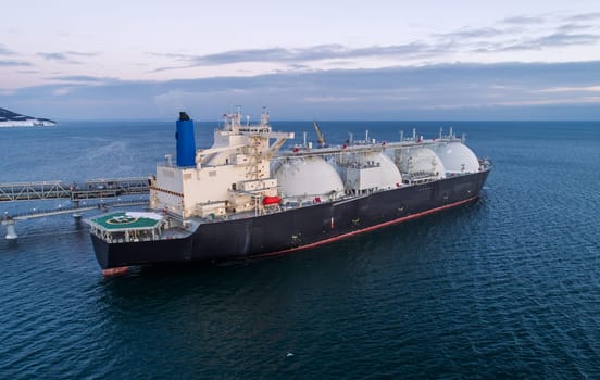 Aerial of Liquified Natural Gas LNG carrier moored to a small gas terminal. Fuel crisis. Sanctions.