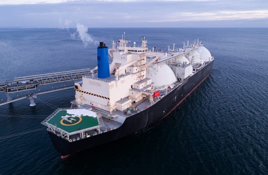 Aerial of Liquified Natural Gas LNG carrier moored to a small gas terminal. Fuel crisis. Sanctions.