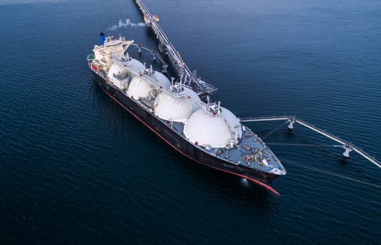 Aerial of Liquified Natural Gas LNG carrier moored to a small gas terminal. Fuel crisis. Sanctions.