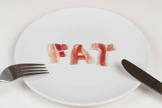 A plate with the word fat on it, accompanied by a fork and knife, symbolizing unhealthy eating habits.