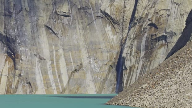 Enthralling video of glacier water flowing over rocks into a vibrant lake.