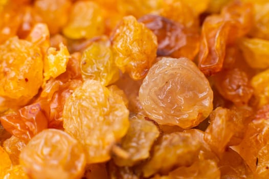 Background of a large number of dried yellow golden grapes. Raisin. Vegetarian diet.