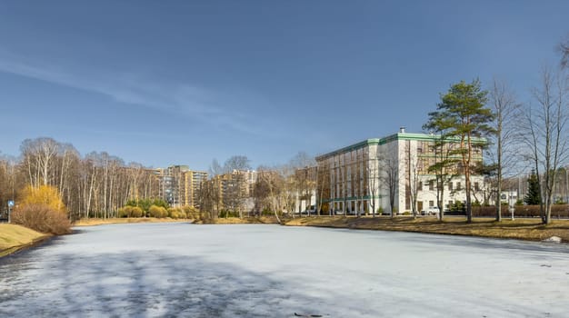 Russia, St.Petersburg, 28 March 2024: The main building of the sports base of the Zenit football team next to the Specific Park on a sunny day, ice on the pond. High quality photo