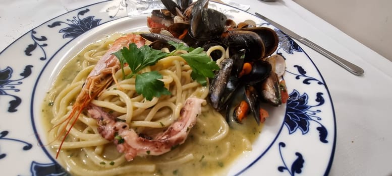 Close-up of a delicious seafood linguine pasta dish with mussels. Shrimp. And squid. Garnished with parsley. Freshly cooked and beautifully presented on a plate